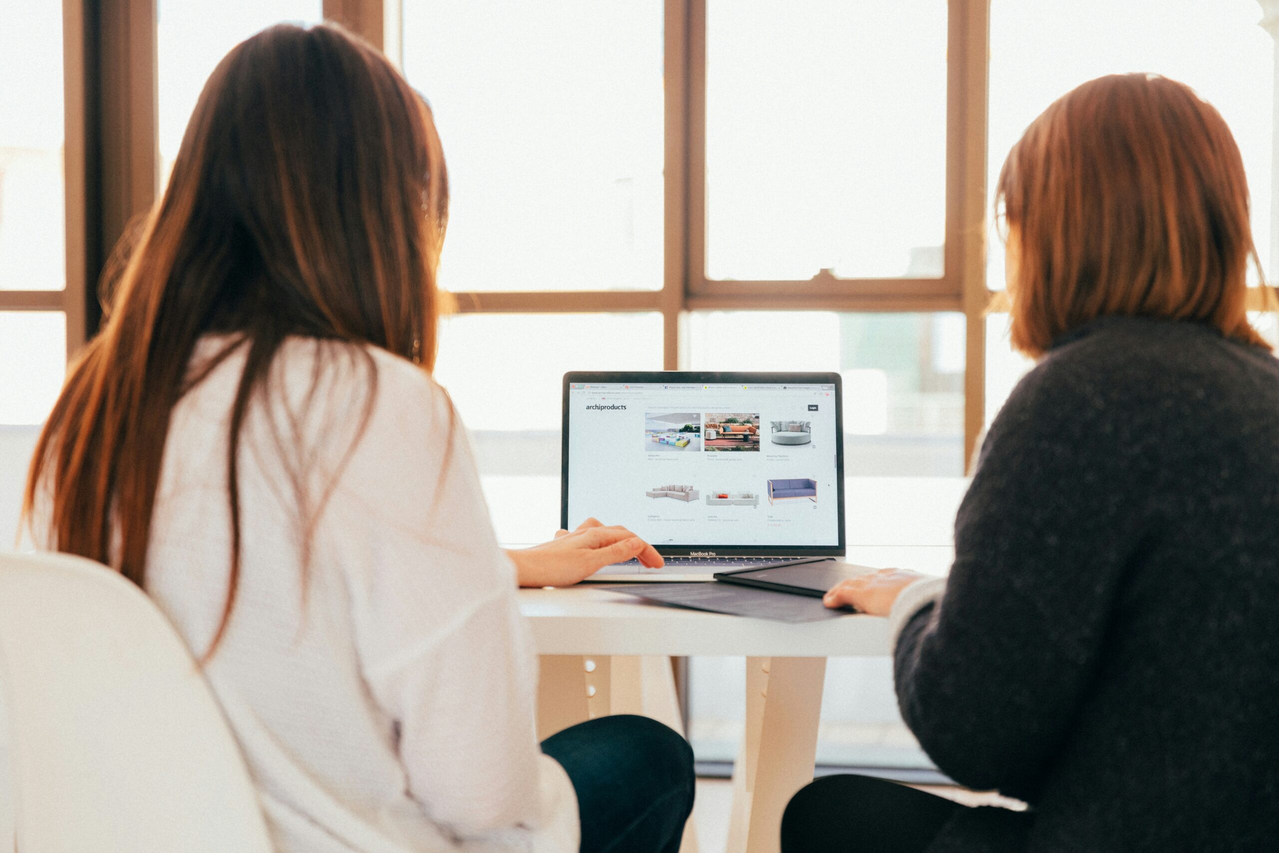 Bakgrunnsbilde av person som viser en annen person en pc-skjerm. Google Analytics
